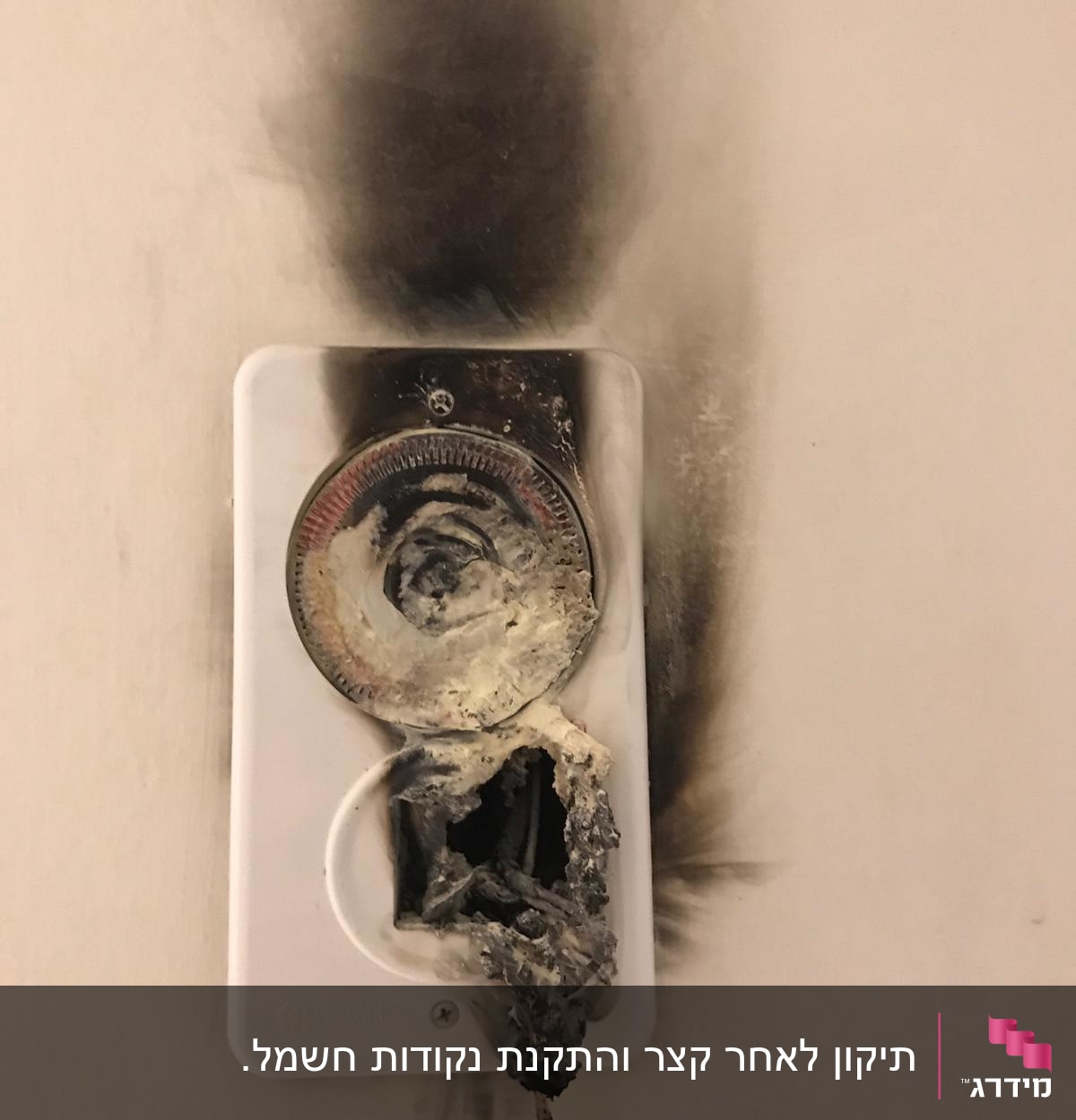 שקע חשמלי שרוף עם סימני פיח על הקיר